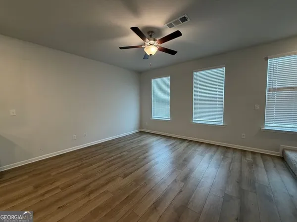 an empty room with a empty space and a ceiling fan