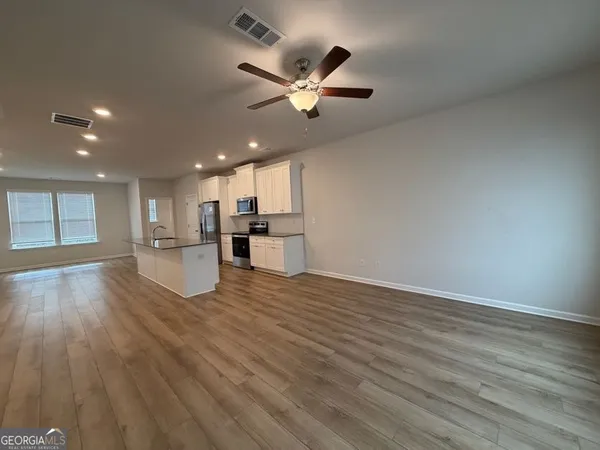 an empty room with closet and a ceiling fan