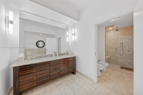 a bathroom with a double vanity sink a toilet and a shower