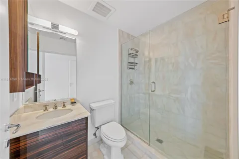 a bathroom with a granite countertop sink toilet and shower