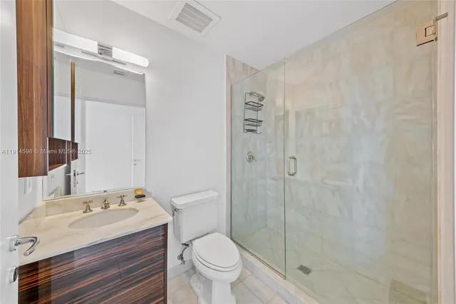 a bathroom with a granite countertop sink toilet and shower