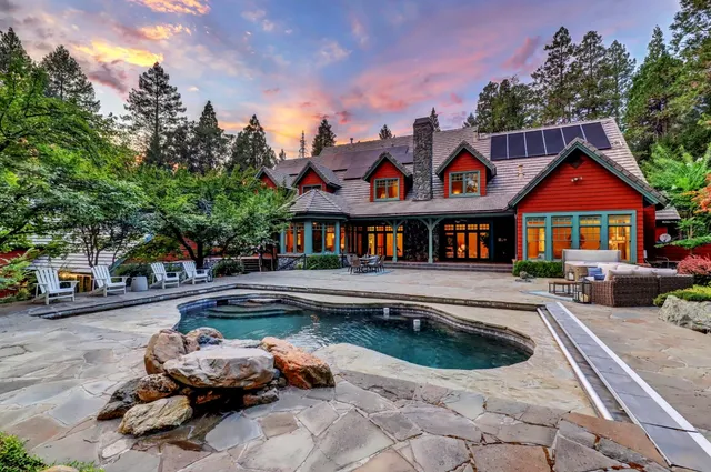 a front view of a house with swimming pool and sitting area
