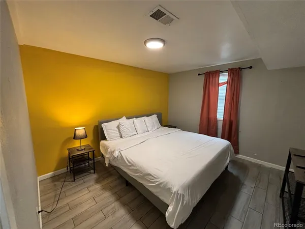 a bedroom with a bed and wooden floor
