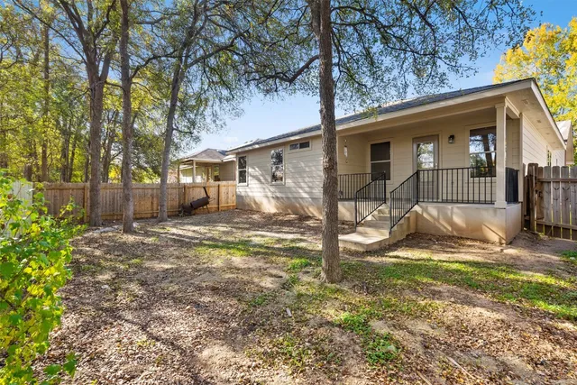 a view of a house with backyard and a tree