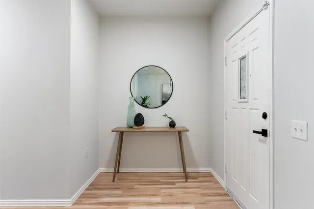 a view of a room with wooden floor and mirror