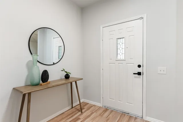 a dining room with chandelier and wooden floor
