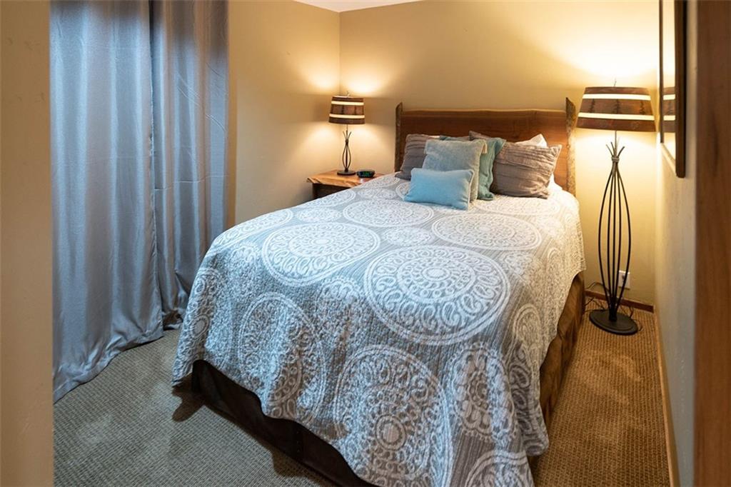 24 River Run Road, Unit 2906 Keystone, CO 80435 - Photo 6 of 15 a bed sitting in a bedroom next to a bathroom