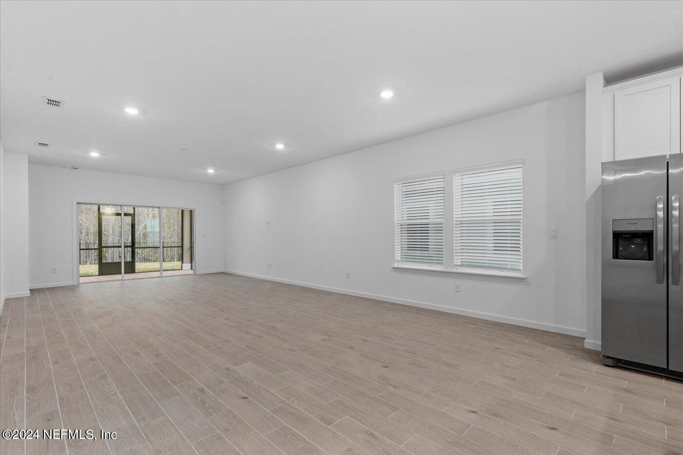 214 Blue Cypress Trail St. Augustine, FL 32084 - Photo 12 of 28 an empty room with windows and refrigerator