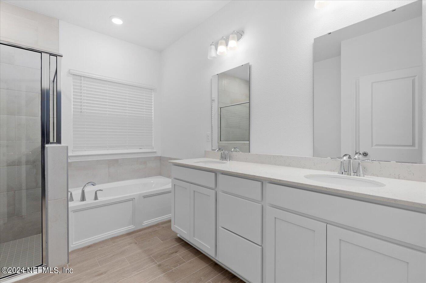 214 Blue Cypress Trail St. Augustine, FL 32084 - Photo 22 of 28 a bathroom with a double vanity sink and mirror with shower