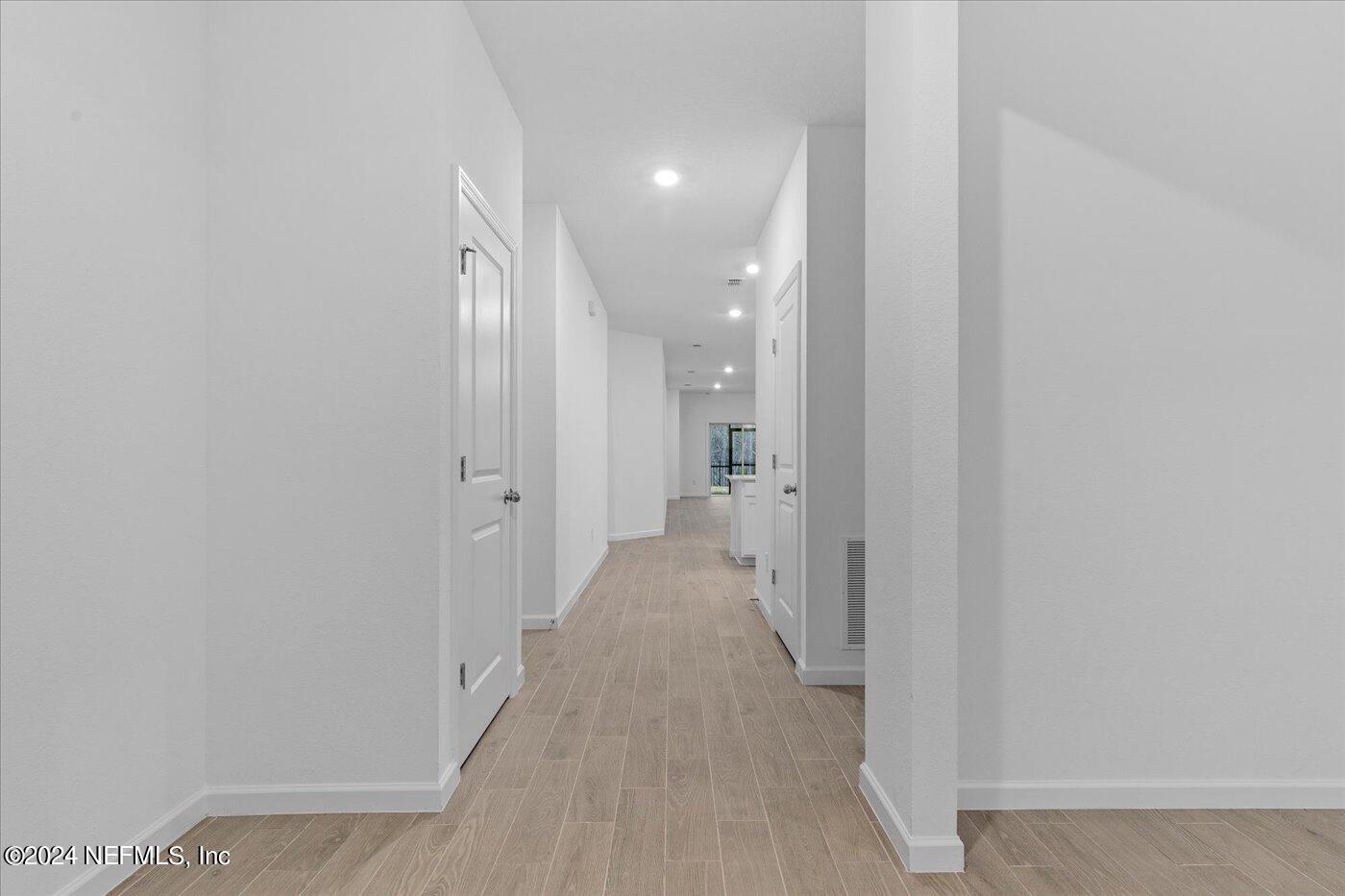 214 Blue Cypress Trail St. Augustine, FL 32084 - Photo 6 of 28 a view of a hallway with wooden floor and a bathroom