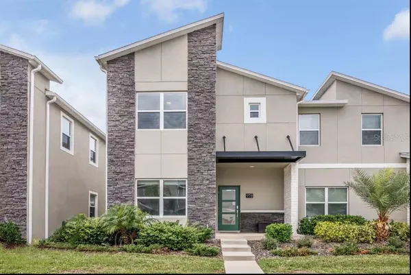 a view of a house with brick walls and flower plants