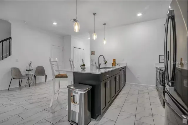 a kitchen with stainless steel appliances a sink and a refrigerator