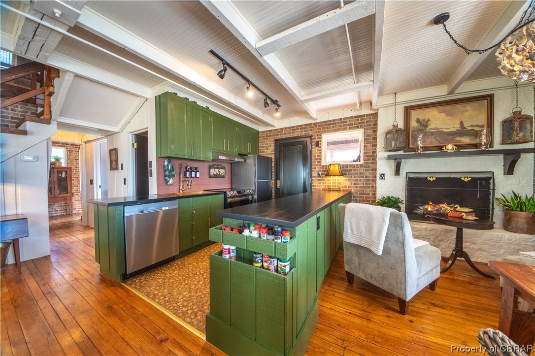 2515 Red Bank Road Gloucester, VA 23061 - Photo 27 of 49 Kitchen featuring stainless steel appliances, rail lighting, beam ceiling, brick wall, and green cabinets