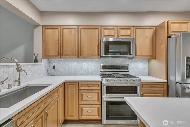 a kitchen with granite countertop a stove a sink and a microwave