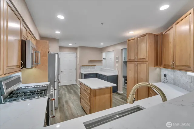 a kitchen with stainless steel appliances granite countertop a refrigerator sink and white cabinets