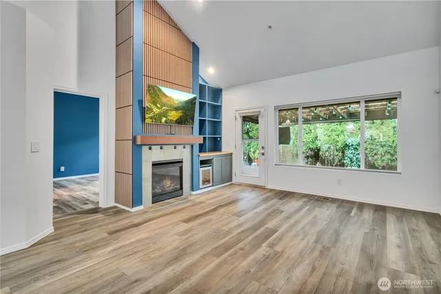 a view of an empty room with a fireplace and a window