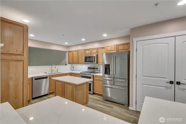 a kitchen with stainless steel appliances granite countertop a refrigerator and a stove