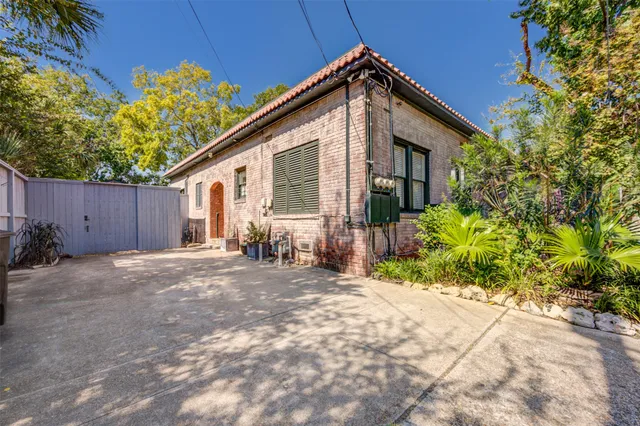 a front view of a house with a yard and potted plants