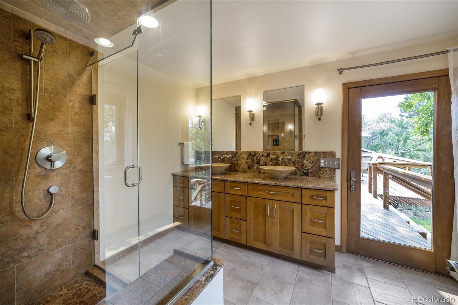 4780 McKinley Drive Boulder, CO 80303 - Photo 14 of 37 a bathroom with a double vanity sink a large mirror and a shower