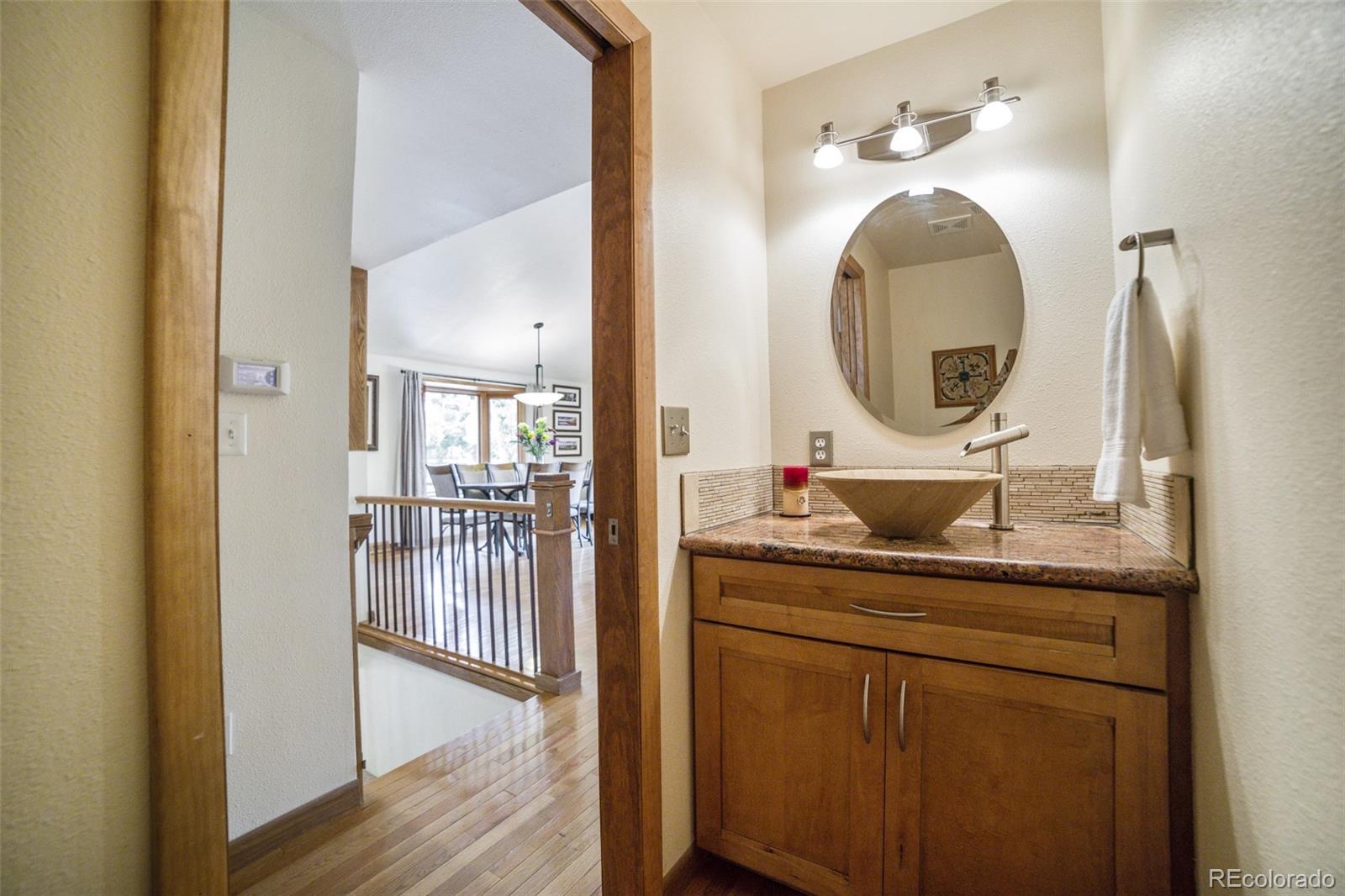 4780 McKinley Drive Boulder, CO 80303 - Photo 16 of 37 a en suite bathroom with a granite countertop sink and a mirror