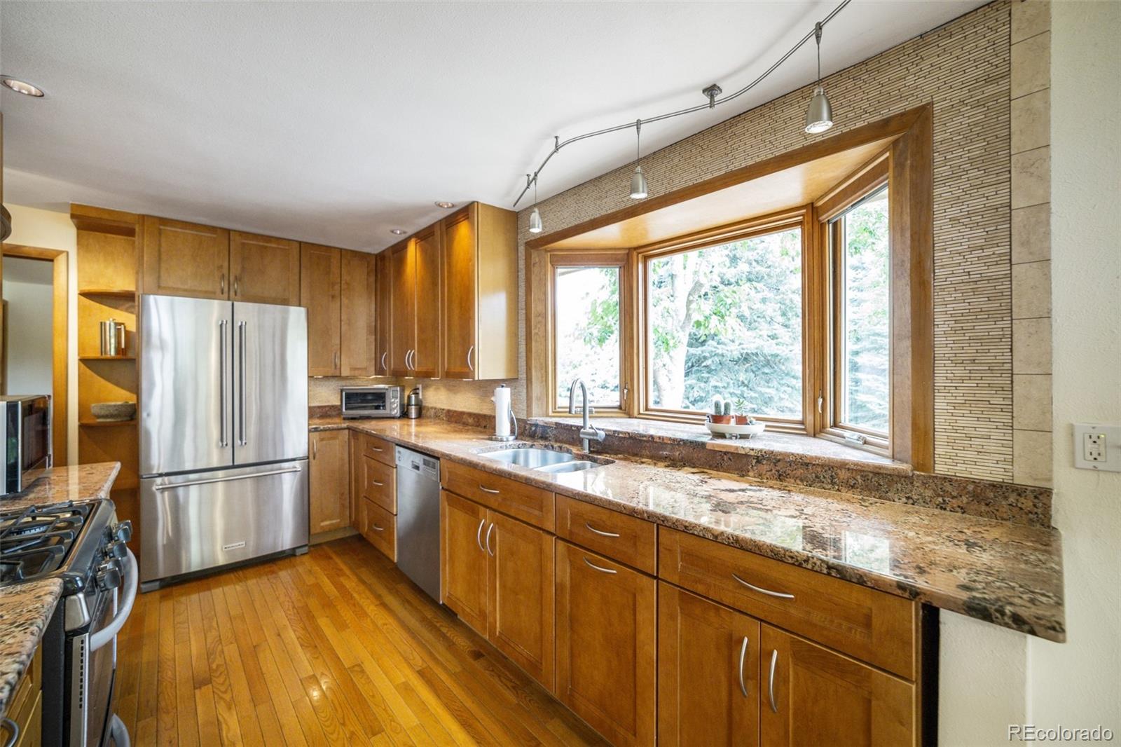 4780 McKinley Drive Boulder, CO 80303 - Photo 4 of 37 a kitchen with a window wooden floor and stainless steel appliances