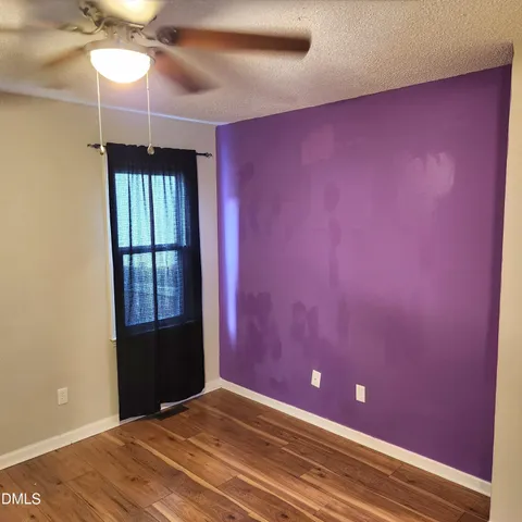 en empty room with windows and fan