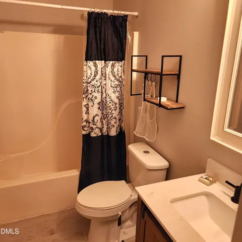 a bathroom with a toilet and a shower curtain