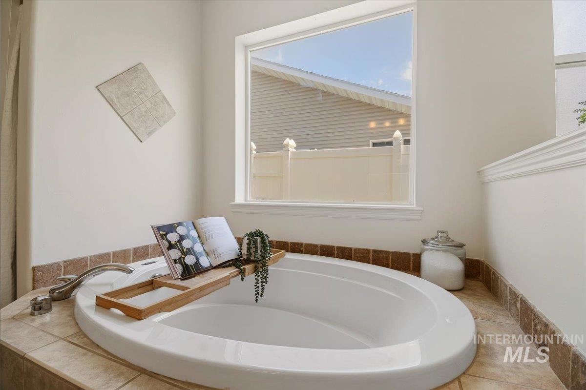 2032 Talus Loop Twin Falls, ID 83301 - Photo 36 of 43 Built-in soaking tub with brushed nickel fixtures, surrounded by a tiled deck and a window offering natural light
