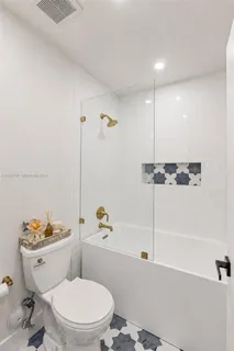 a white toilet sitting next to a bathroom sink and tub