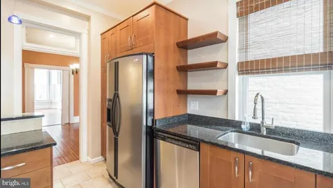 a kitchen with stainless steel appliances granite countertop a sink and a refrigerator