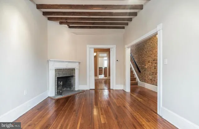 a view of empty room with wooden floor and fireplace