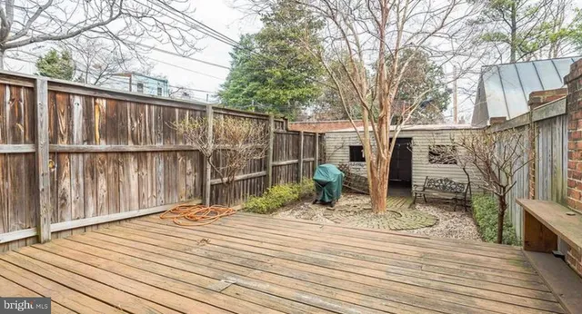 a backyard of a house with wooden floor table and chairs