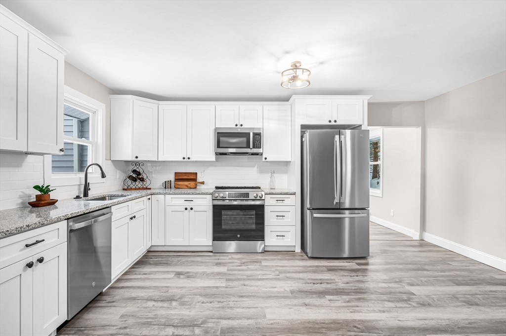 270 South Main Street Orange, MA 01364 - Photo 19 of 41 a kitchen with stainless steel appliances granite countertop a refrigerator stove a sink and dishwasher with wooden floor