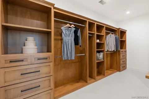 a view of walk in closet with clothes and shoes