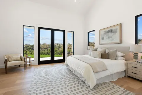 a bedroom with a bed and a large window