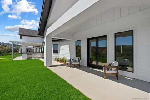 a view of a house with a yard and potted plants