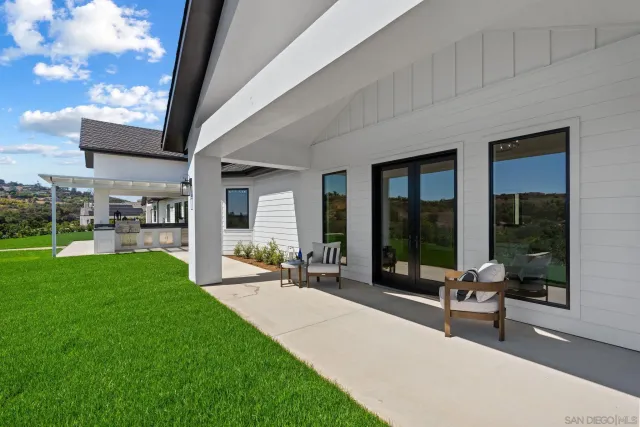a view of a house with a yard and potted plants