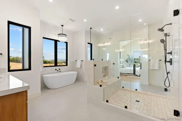 a bathroom with a tub shower and mirror
