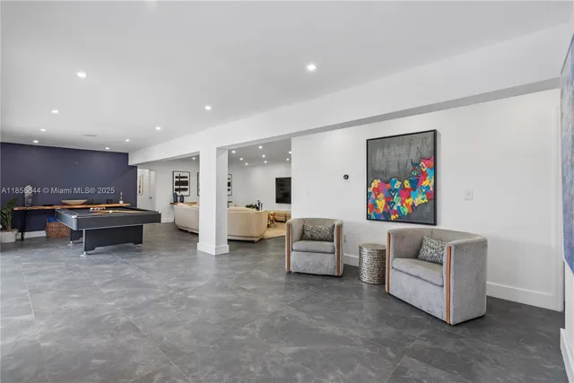 a room with wooden floor pool table and windows