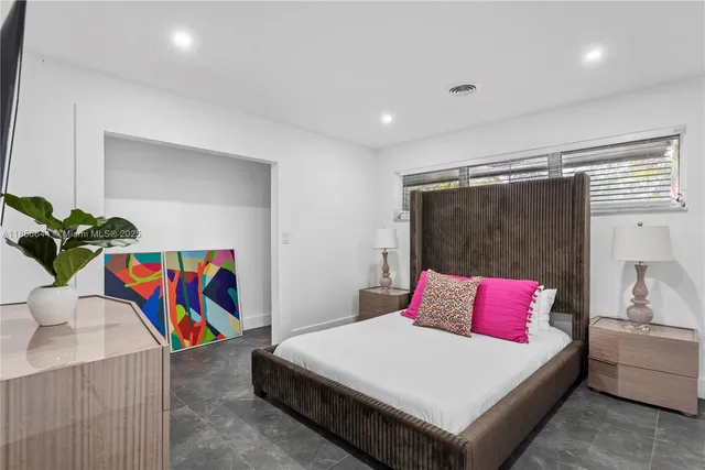 a bedroom with a large bed and a night stand