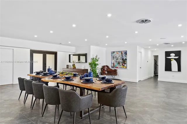 a room with lots of furniture and a dining table with a potted plant