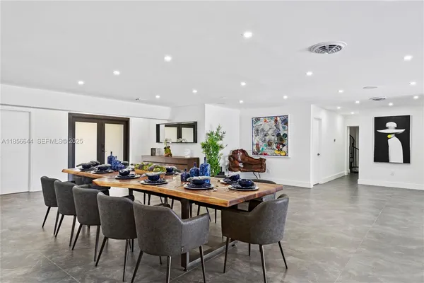 a room with lots of furniture and a dining table with a potted plant