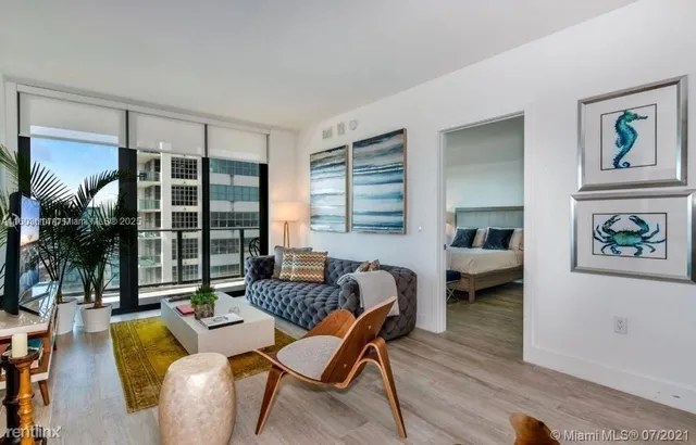 a living room with furniture and a floor to ceiling window