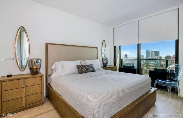 a bedroom with a bed a mirror and lamp