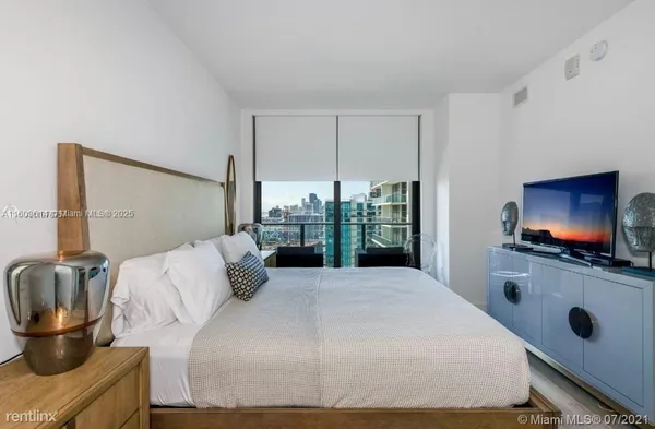 a bedroom with a bed and a flat screen tv