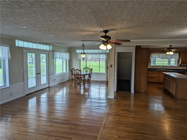 an empty room wooden floor and a kitchen view