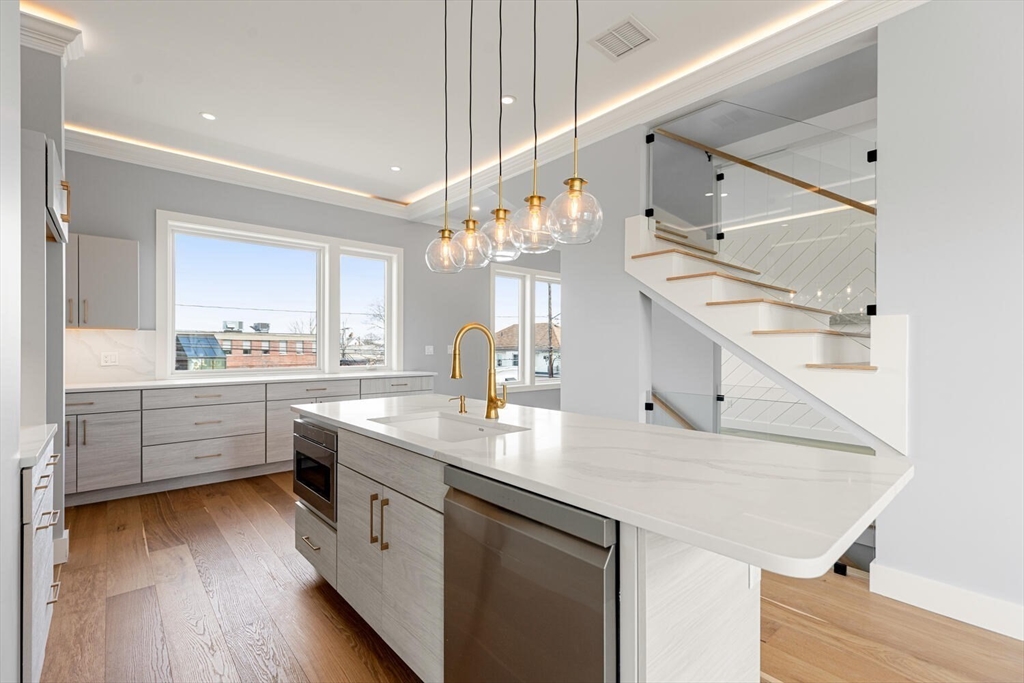 308 Newton Street, Unit 1F Waltham, MA 02453 - Photo 14 of 23 a kitchen with a sink dishwasher a stove and white cabinets with wooden floor