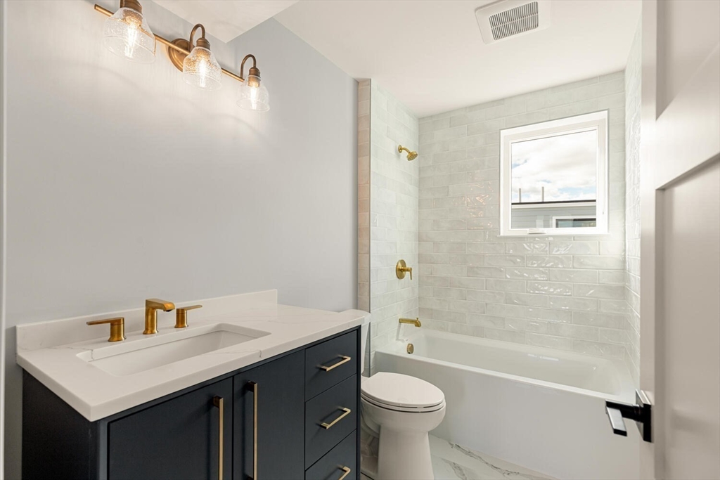 308 Newton Street, Unit 1F Waltham, MA 02453 - Photo 22 of 23 a bathroom with a sink a toilet and shower