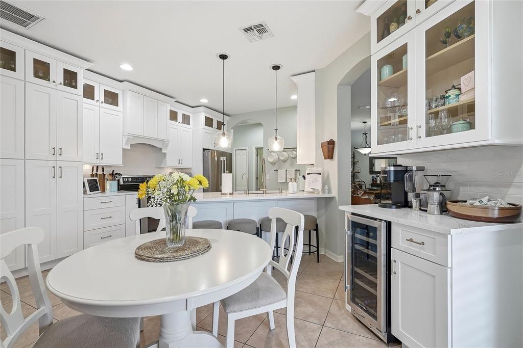 16748 Midsummer Lane Spring Hill, FL 34610 - Photo 20 of 52 a kitchen with stainless steel appliances kitchen island granite countertop a dining table chairs and white cabinets