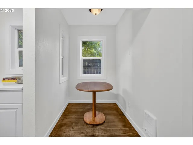 a picture of a room with a window and wooden floor